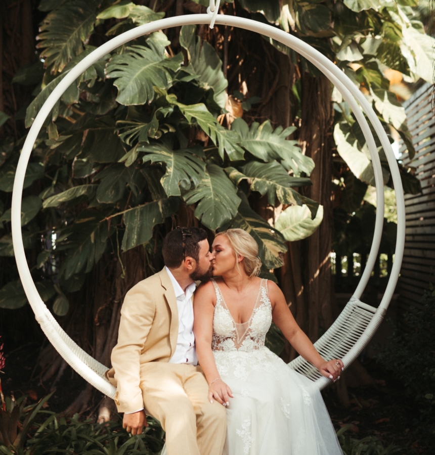 Bride and Groom sitting on a swing kissing