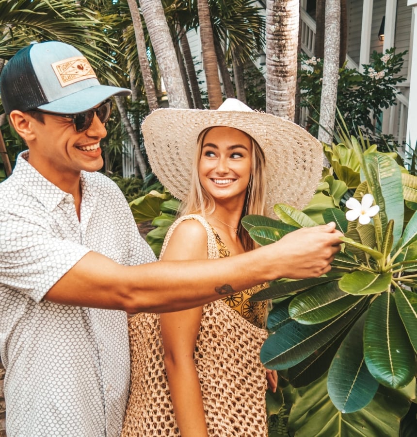 A young couple exploring Key West and looking at a flower