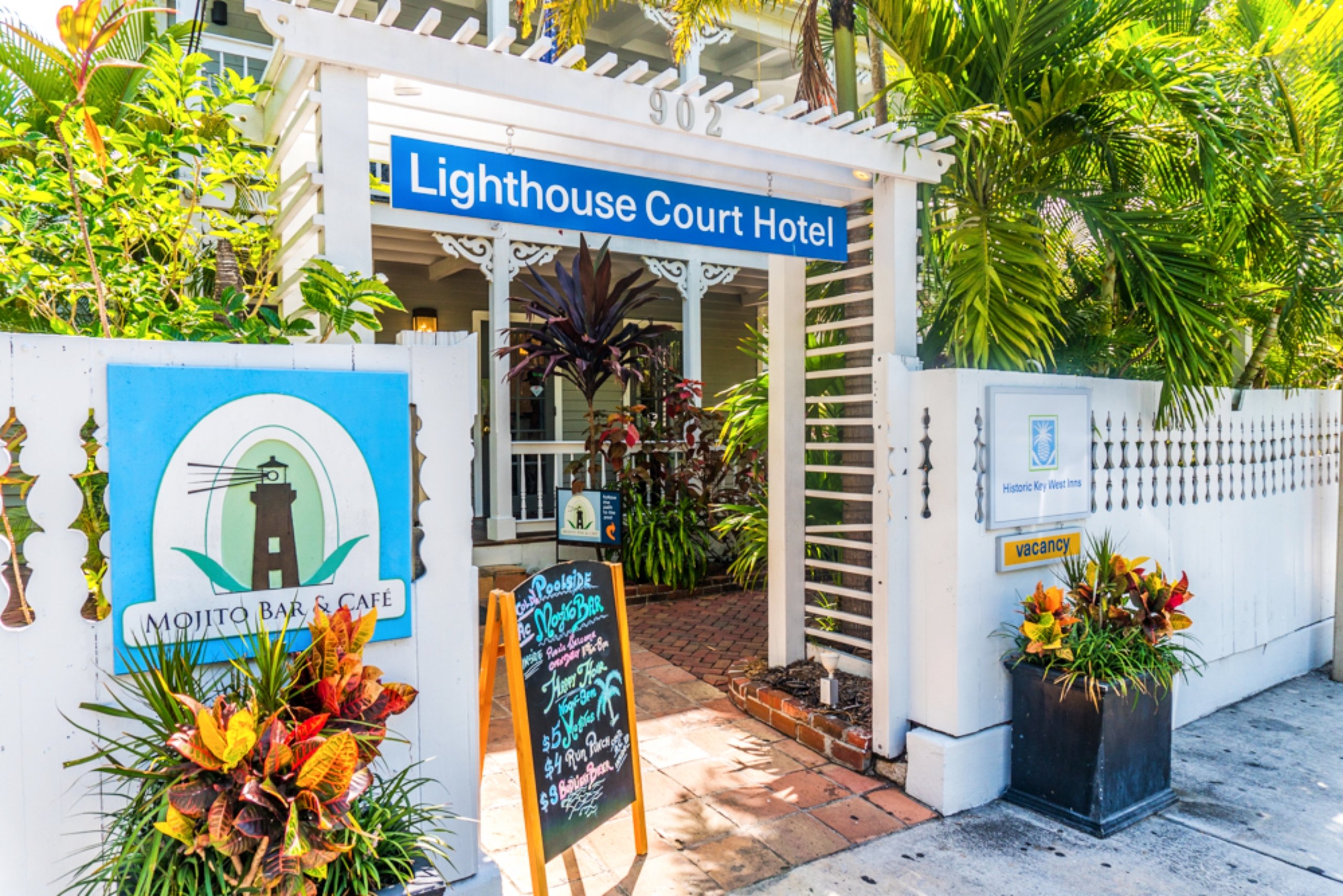 The outside of the old Lighthouse Court Hotel with a white wooden fence and flower planters